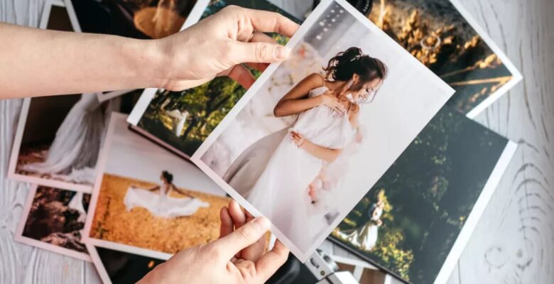 women's hands holding wedding photos