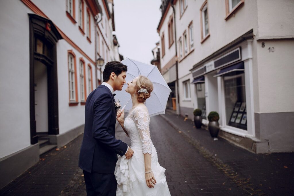 Groom and bride with umbrella kissing