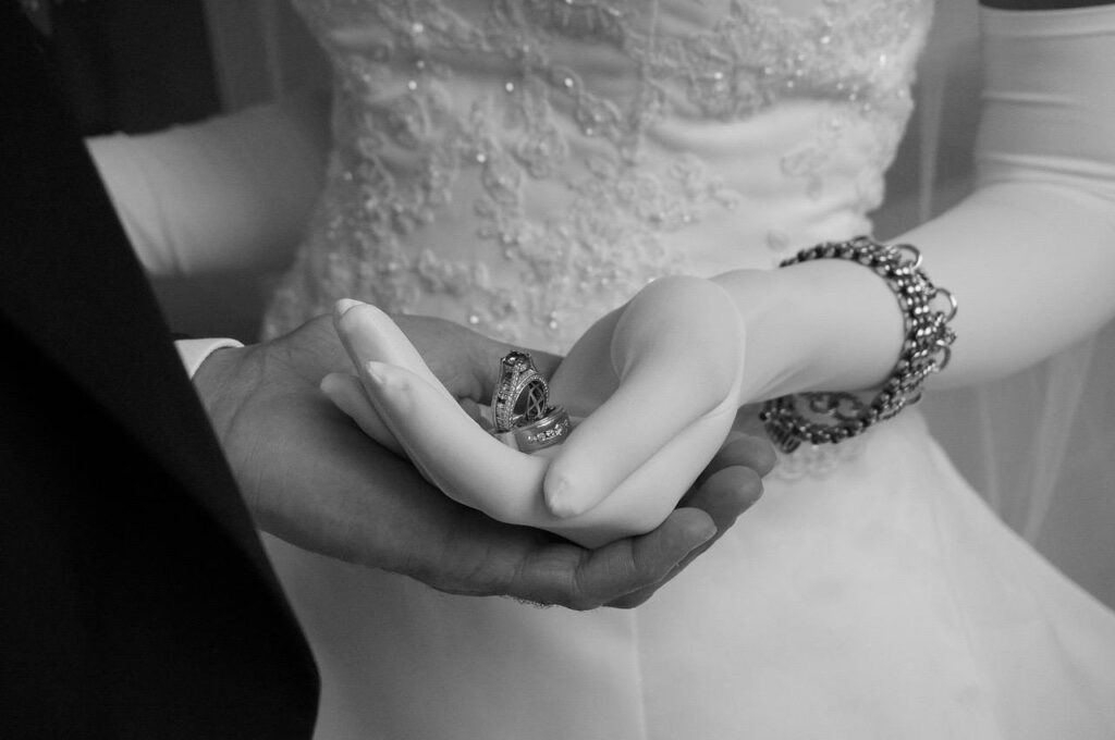 Hands of the bride and groom holding rings