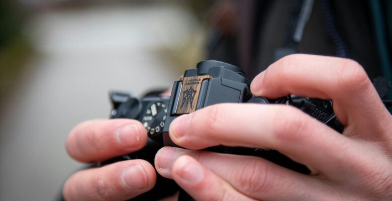 Close-up of hands adjusting settings on a digital camera