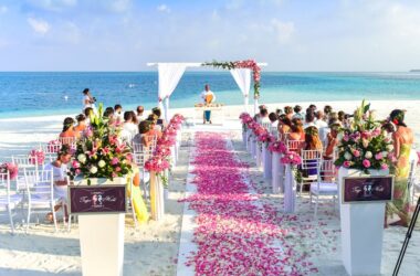 A beach wedding setup with floral decorations and guests seated