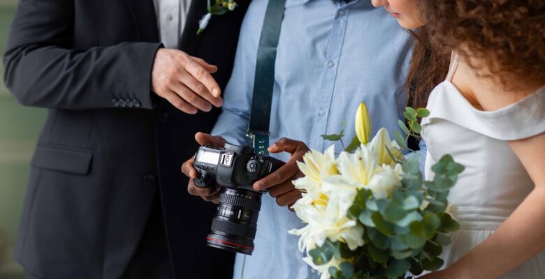 Side view of photographer and married couple discuss photos