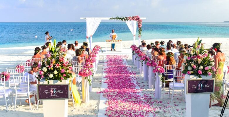 A beach wedding setup with floral decorations and guests seated